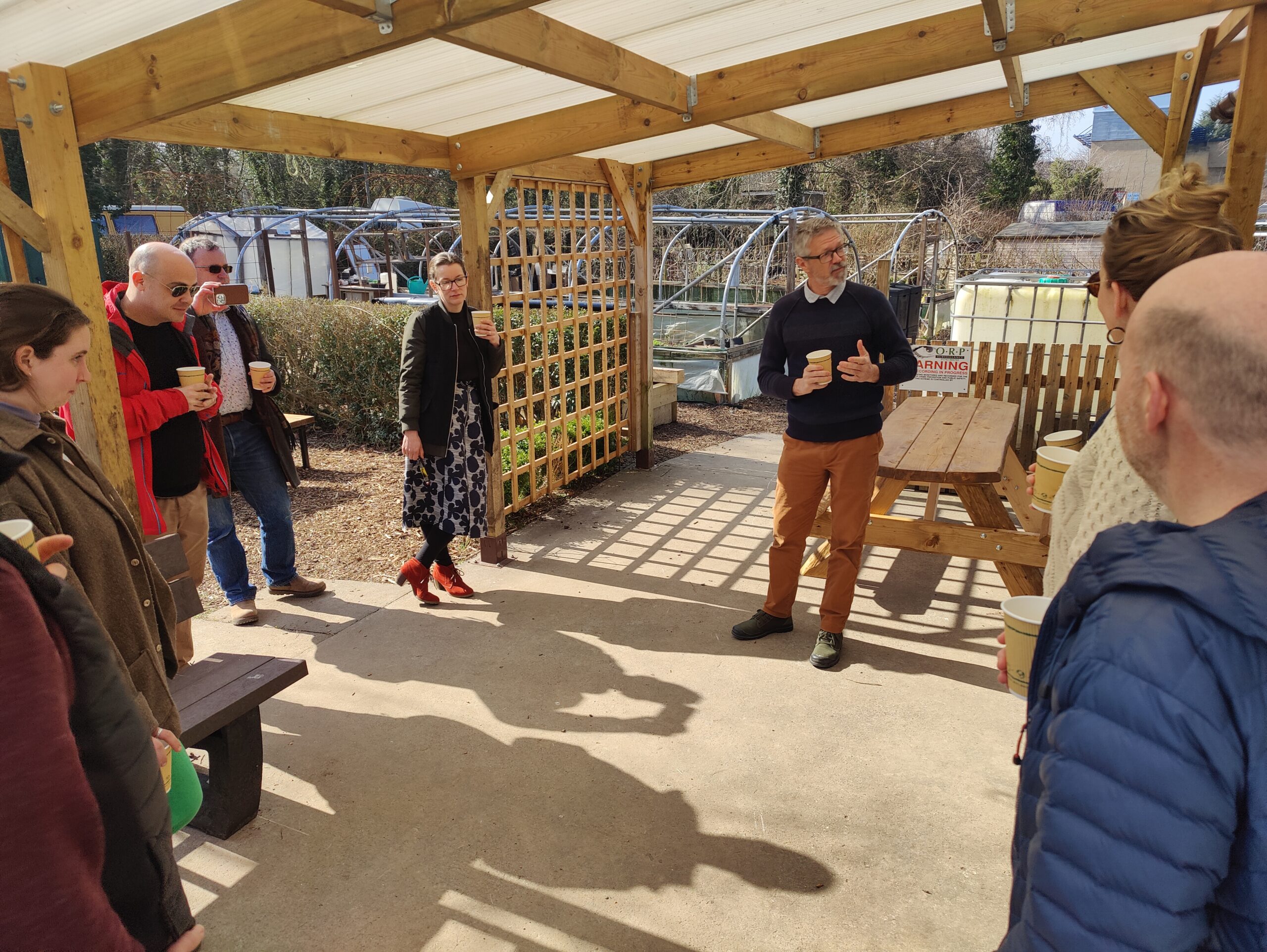 Cultivate tour Members of the Procurement for Good project team standing in Cultivate's project garden, being given a tour by the manager Richard.