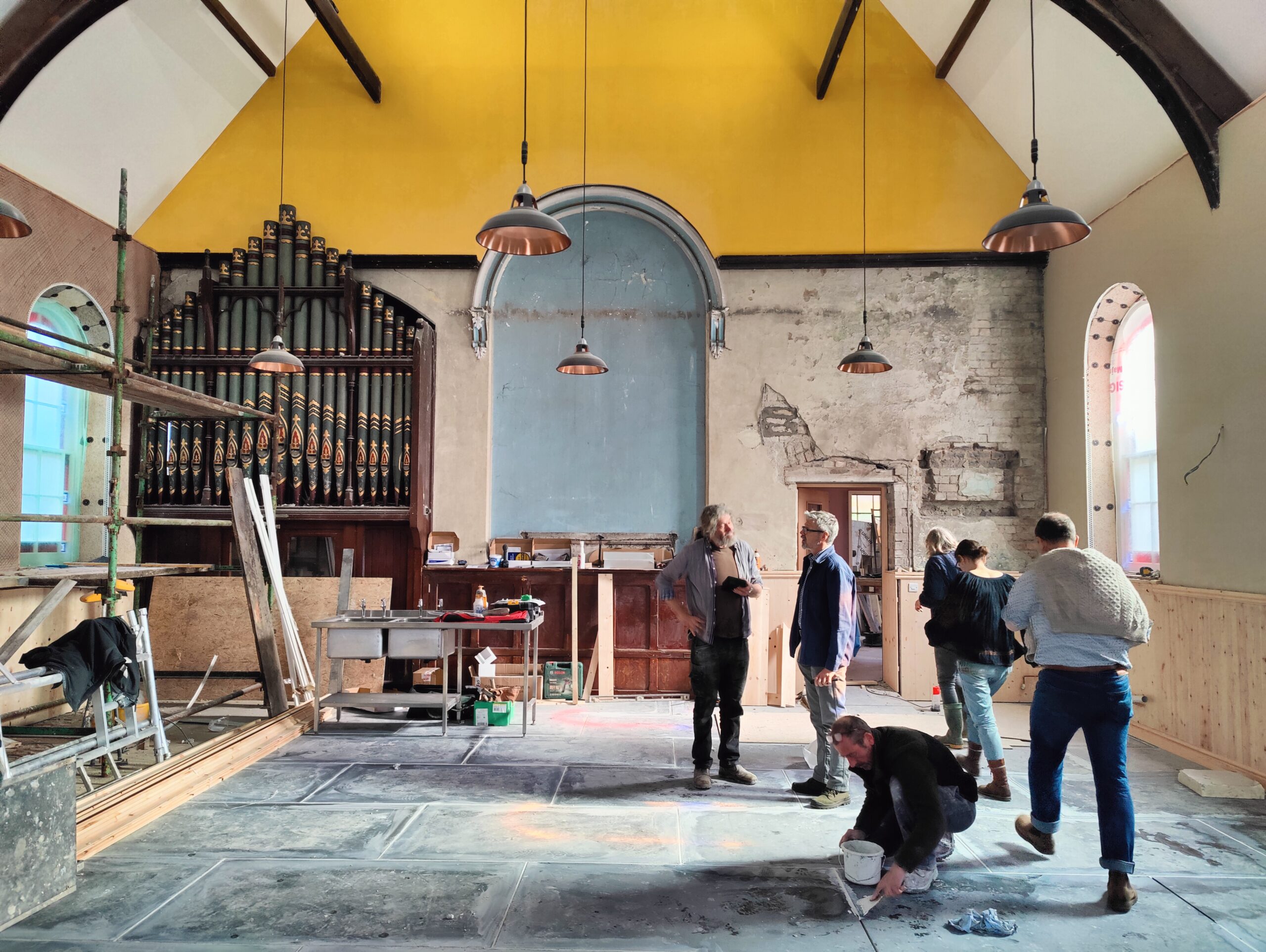 Hanging Gardens A partially renovated old chapel in Llanidloes, with builders and visitors milling about